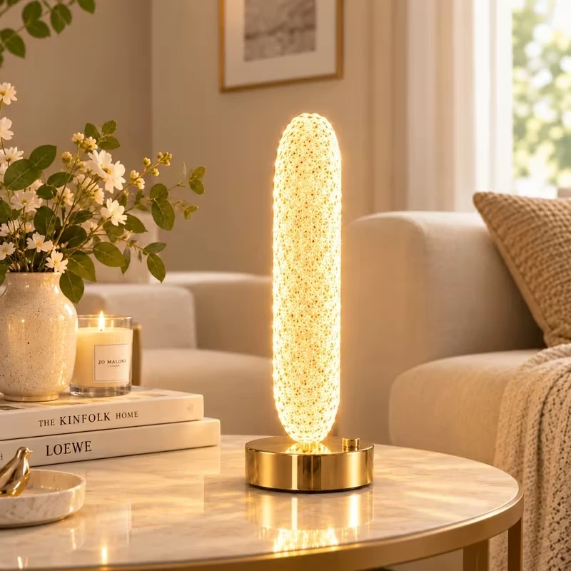 Side view of the lamp glowing warmly on a round marble table, showing how slim the shade is from the side